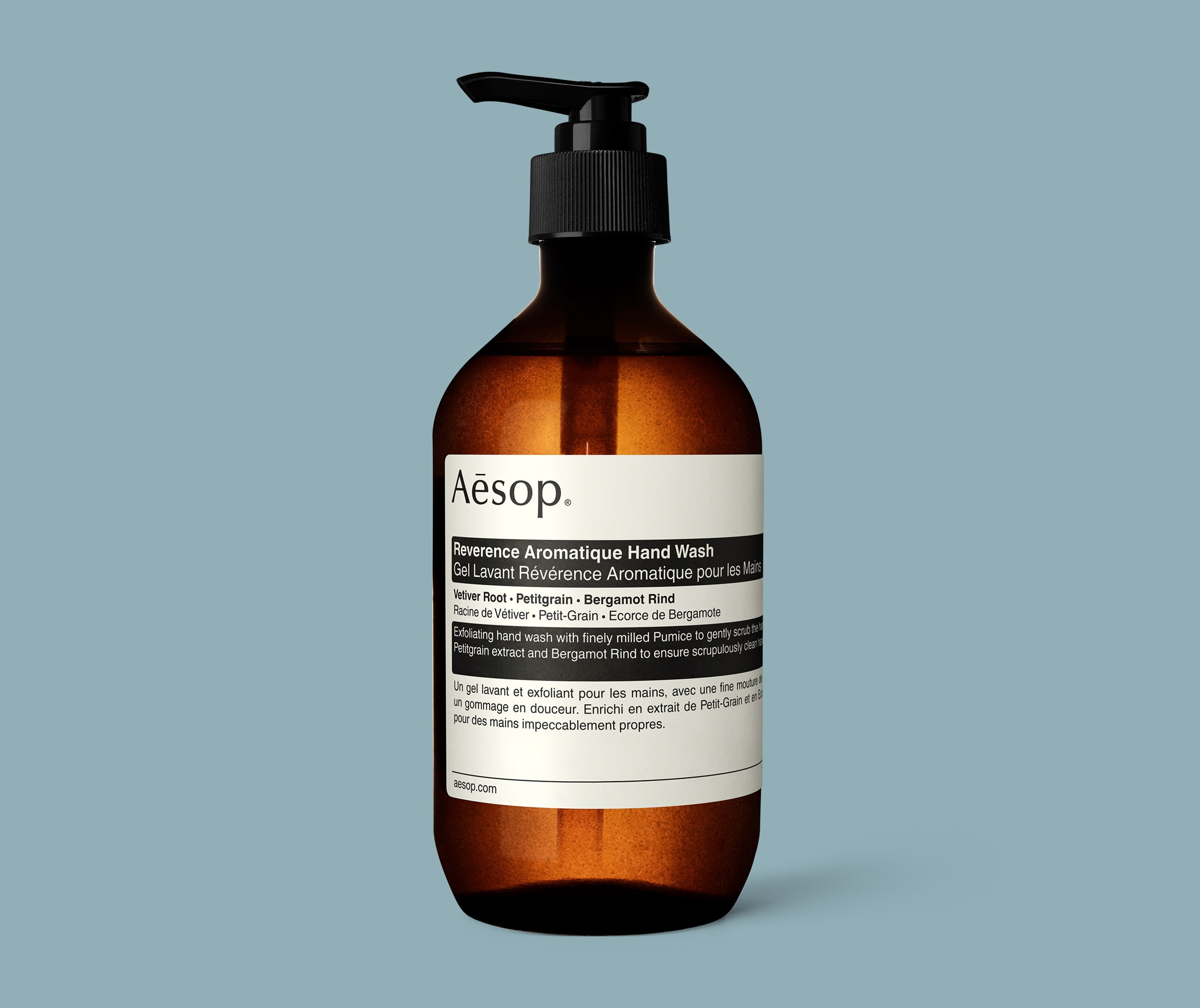 Reverence Aromatique Hand Wash in amber bottle with pump in blue background