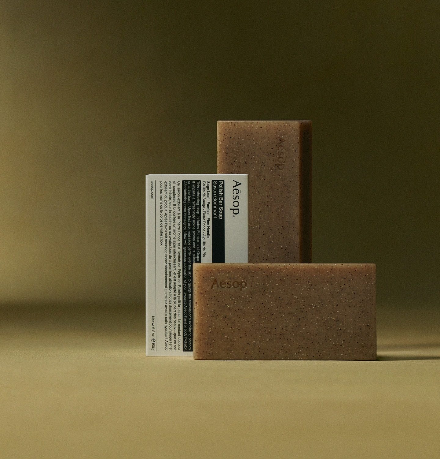 Aesop Polish Bar Soaps placed next to the packaging in dark yellow textured background